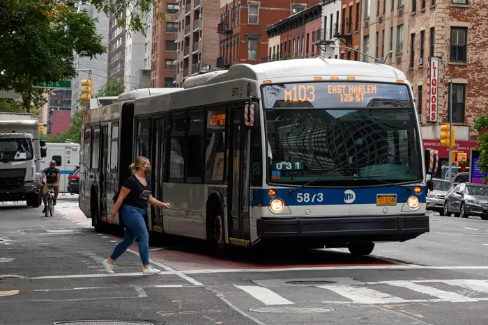 An MTA bus drives along the street in Manhattan.